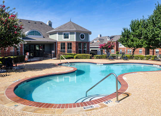A swimming pool with a brick border and a slide.