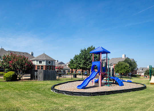 A playground with a blue slide and a blue canopy.
