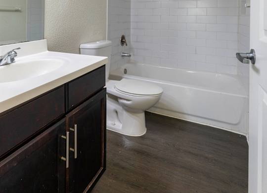 A white bathroom with a toilet, sink, and tub.