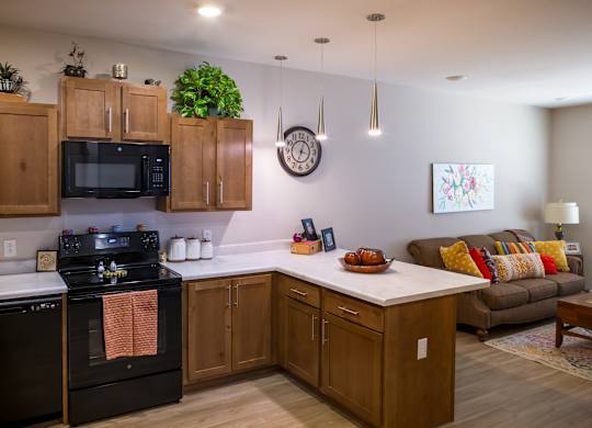 A kitchen with wooden cabinets and a black stove top oven.