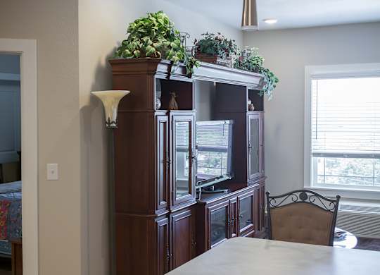 A kitchen with a wooden cabinet and a white counter.