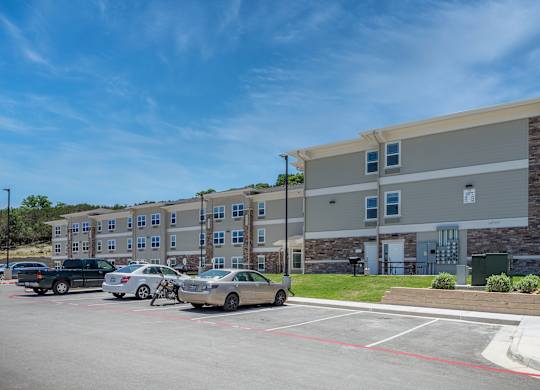 A parking lot with cars and a building in the background.