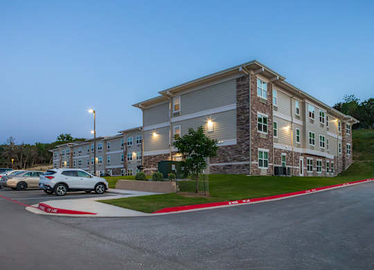 A parking lot with cars and a building in the background.
