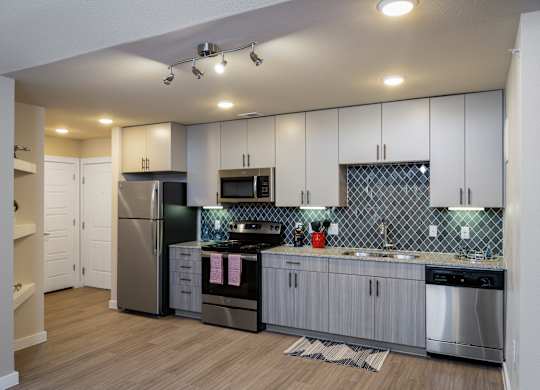 A modern kitchen with stainless steel appliances and white cabinets.