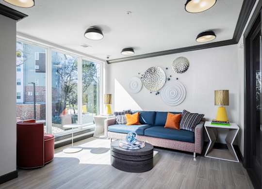 A modern living room with a blue sofa and a yellow side table.