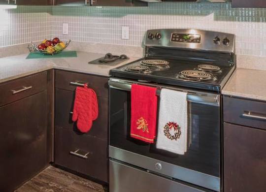A modern kitchen with a stove top oven and microwave above it.