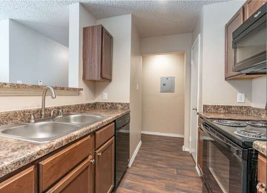 A kitchen with a sink, stove, and microwave.