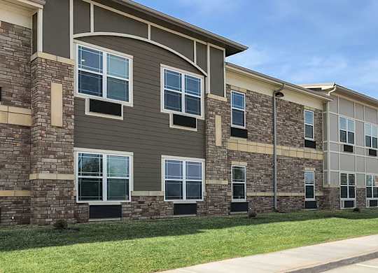 A row of apartment buildings with stone and siding exteriors.