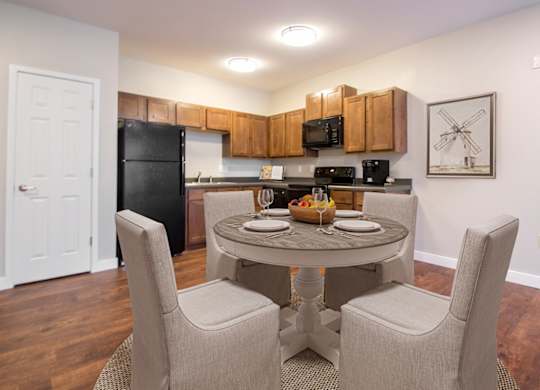 A kitchen with a table and chairs in the middle of the room.