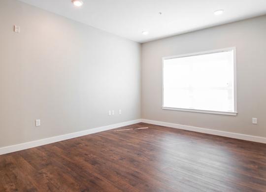 A room with wooden flooring and a window.