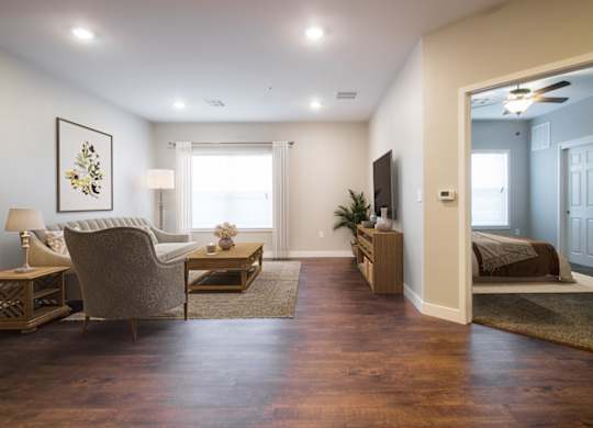 A living room with a chair, a table, and a painting on the wall.