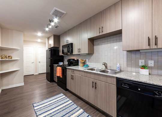 A kitchen with wooden cabinets and black appliances.