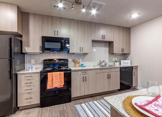 A modern kitchen with a black stove top oven and a black refrigerator.
