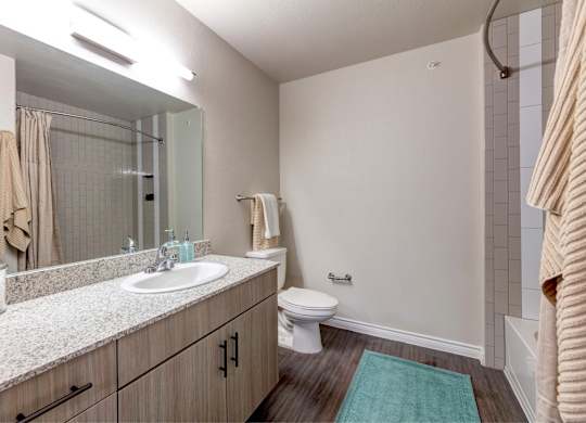 A bathroom with a toilet, sink, and shower.