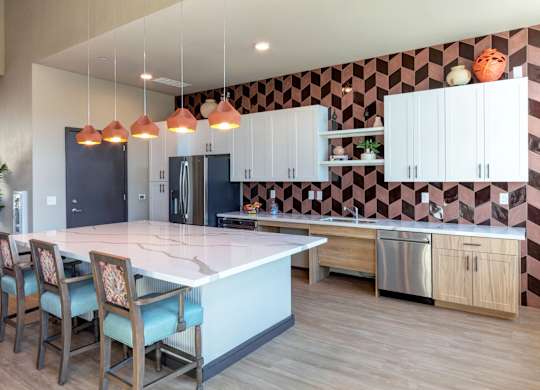 A kitchen with a checkered wallpaper and a white island.