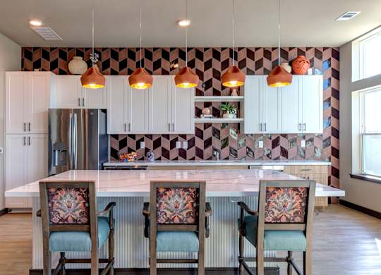 A kitchen with a checkered backsplash and a white countertop.