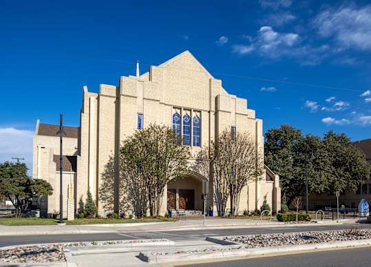 A large beige church with a cross on the top.