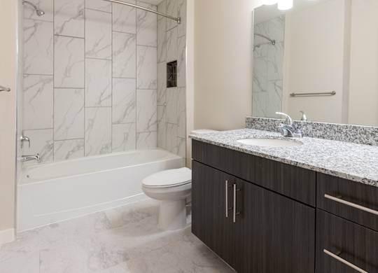 A bathroom with a marble tile floor and a white toilet.
