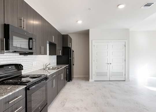 A modern kitchen with dark wood cabinets and a white countertop.