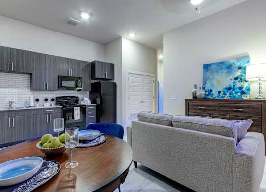 A modern kitchen with a dining table set for two.