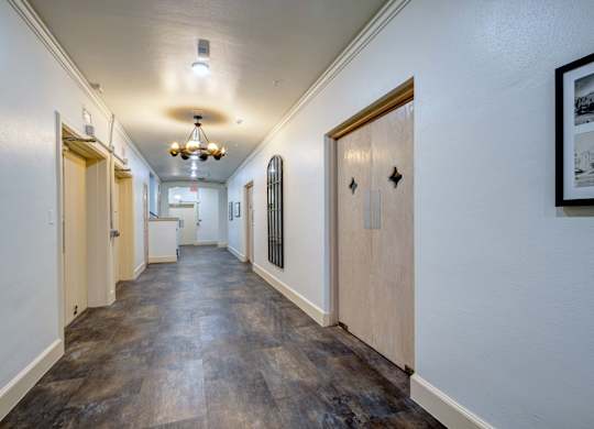 A long hallway with wood floors and white walls.