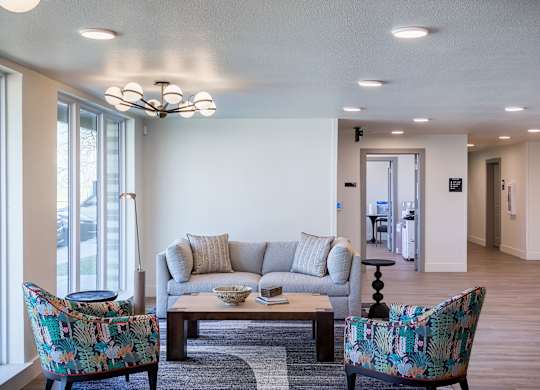 A living room with a couch, two chairs, and a coffee table.
