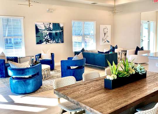 A modern living room with a wooden table and blue chairs.