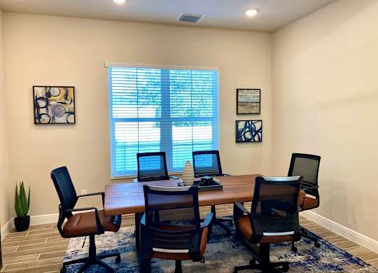 A conference room with a table, chairs, and two laptops.