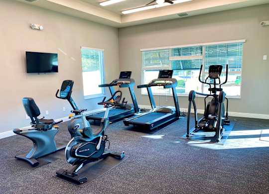 A room with a television and exercise equipment.