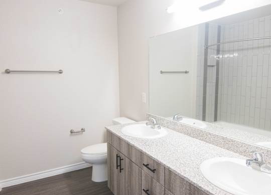 A bathroom with a toilet, sink, and mirror.