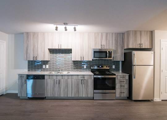A modern kitchen with stainless steel appliances and wooden cabinets.