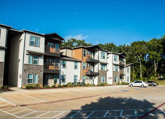 A parking lot in front of apartment buildings.