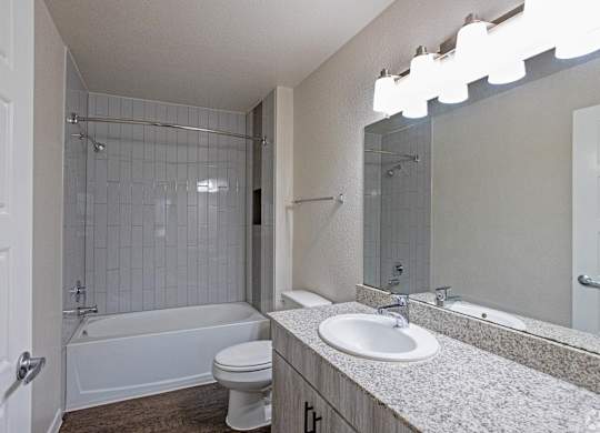 A white bathroom with a toilet, sink, and bathtub.