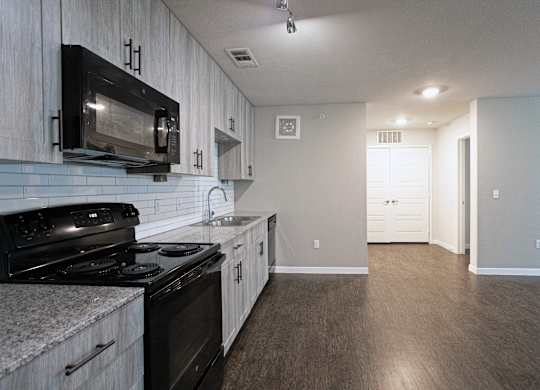 A kitchen with a black microwave above the stove.