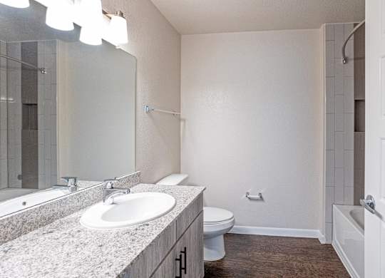 A bathroom with a sink, toilet, and bathtub.