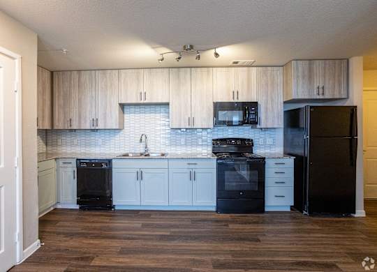 A kitchen with black appliances and wooden cabinets.