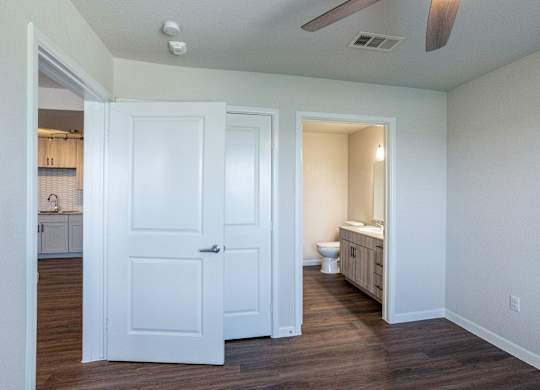 A white door is open to a bathroom with a toilet and sink.