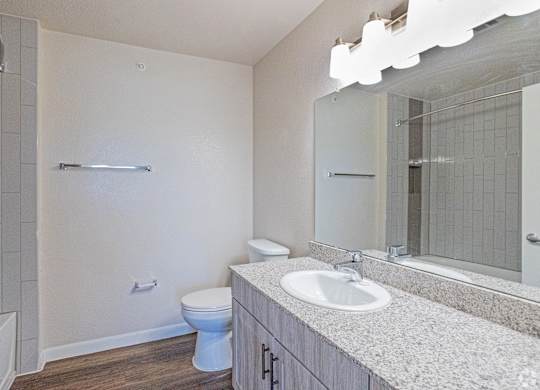 A white bathroom with a toilet, sink, and mirror.