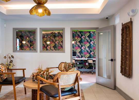 A room with a table and chairs and a painting on the wall.