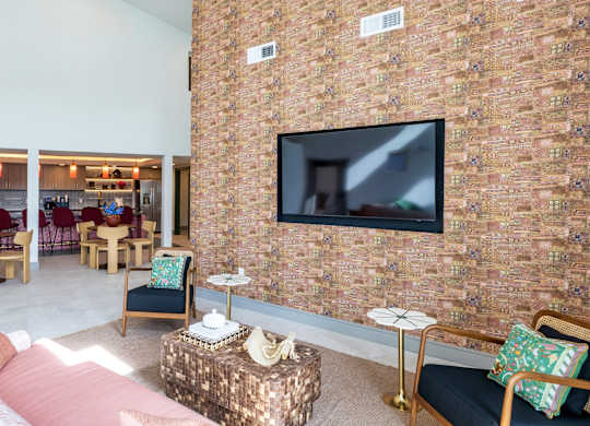 A living room with a brick wall and a flat screen TV mounted on it.
