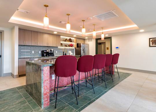 A kitchen with a bar area and chairs.