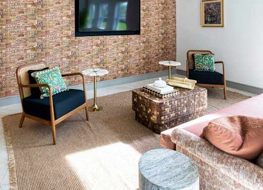 A living room with a brick wall and a flat screen TV.