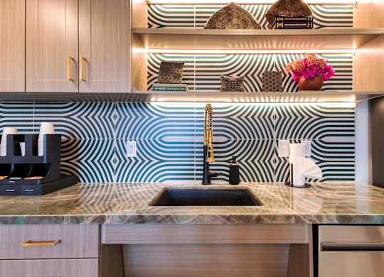 A kitchen with a sink and a coffee maker.