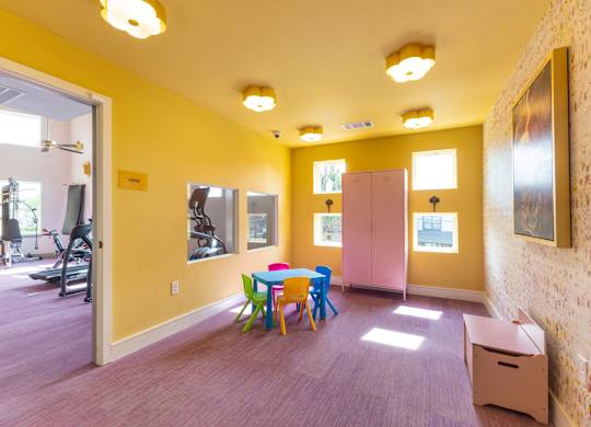 A room with a yellow wall and a purple carpet.