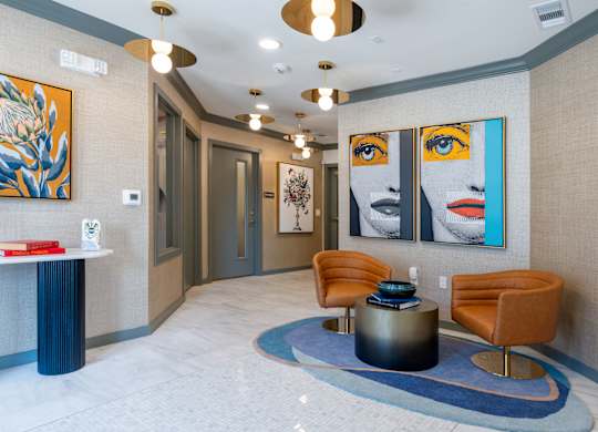 A hallway with a blue carpet and a painting of a woman's face on the wall.