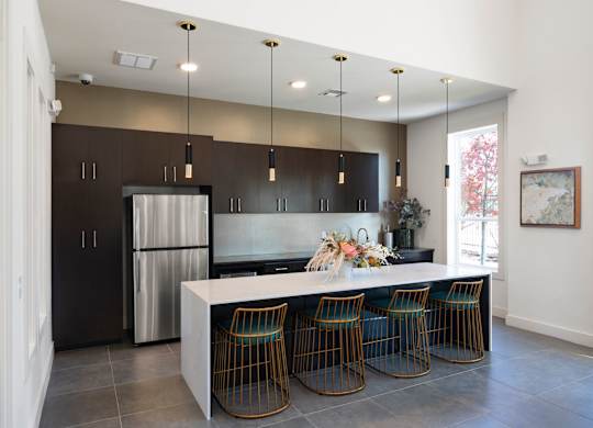 A modern kitchen with a large island and bar stools.