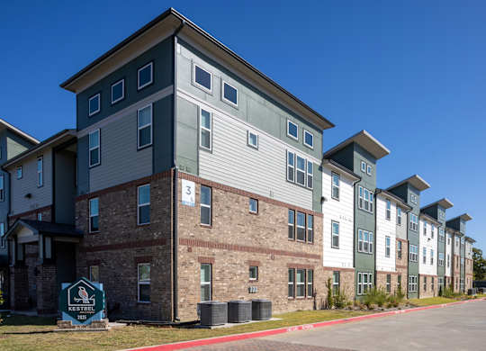 A row of apartment buildings with a sign that says "Neighborhood".