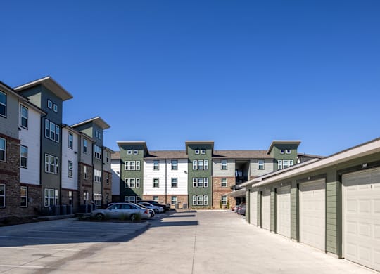 A row of garages in front of apartment buildings.