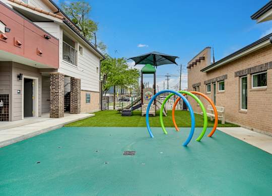 A playground with a green surface and colorful rings.