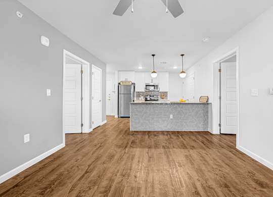A kitchen with a wooden floor and white walls.